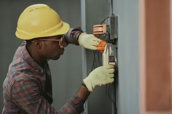 A tradesperson using a power tool on a job site.